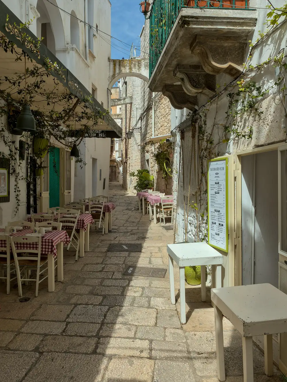 Un vicolo bianco del centro di Cisternino, con i tavoli fuori